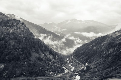 白天山上河流和道路的灰阶摄影